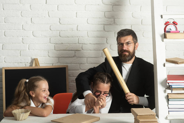 Teacher and schoolgirls on classroom background. Girls and bearded man - Fotografie, Obrázek