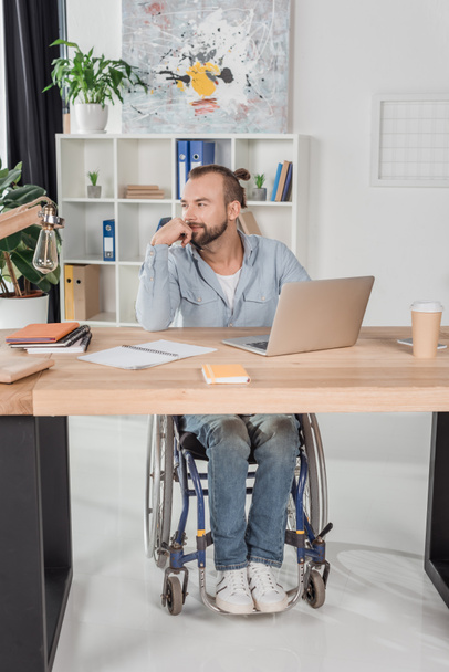disabled man sitting at workplace - Фото, зображення