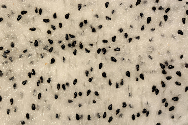 Nahaufnahme Makro aus Samen und Fruchtfleisch einer weißen Drachenfrucht oder Pitahaya für einen natürlichen Fruchthintergrund - Foto, Bild