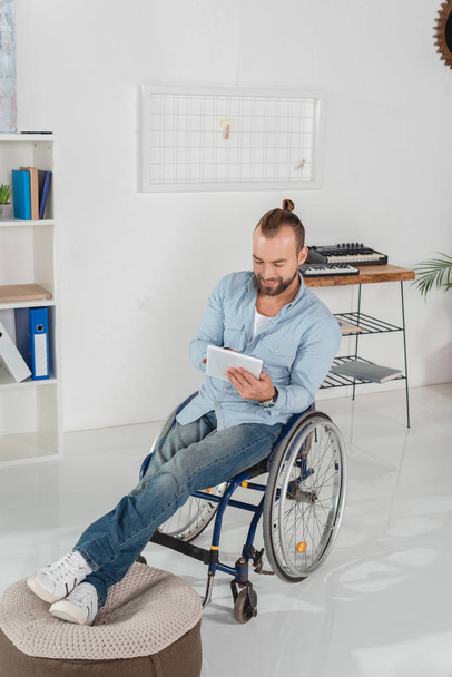 man on wheelchair using tablet - Fotó, kép