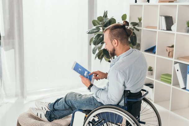 man on wheelchair using tablet - Фото, зображення