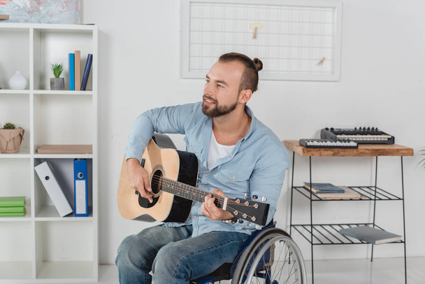 man on wheelchair playing guitar - Foto, Bild