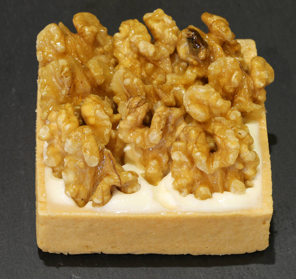 malý dort s vlašskými ořechy v konditorei s pozadím bla - Fotografie, Obrázek