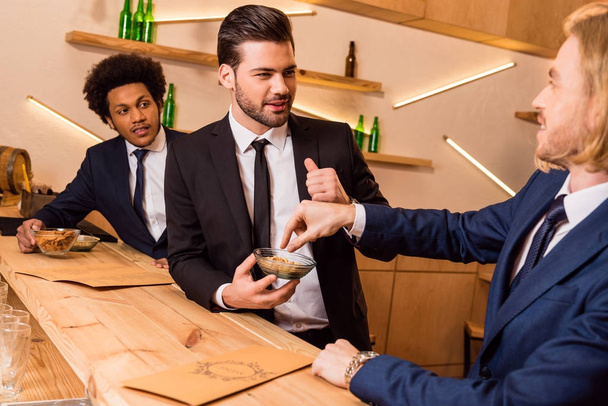 businessmen eating snack in bar - Photo, Image