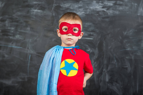 boy superhero in a blue Cape red mask and a red t-shirt with a star - 写真・画像