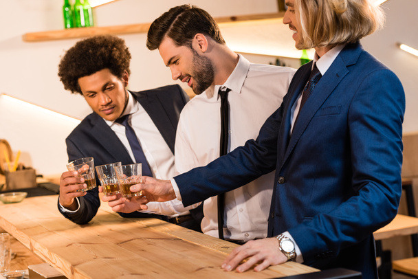 zakenlieden drinken van whisky in staaf - Foto, afbeelding