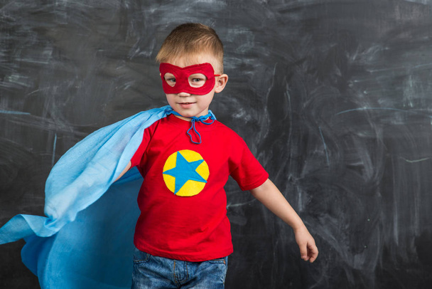 boy superhero in a blue Cape red mask and a red t-shirt with a star - 写真・画像
