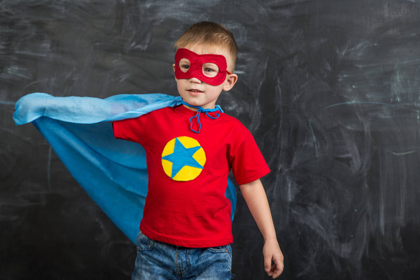 boy superhero in a blue Cape red mask and a red t-shirt with a star - Fotó, kép