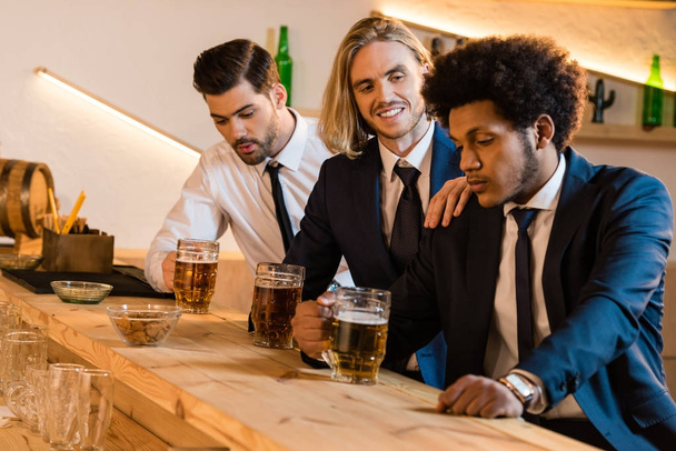 businessmen drinking beer in bar - Fotó, kép