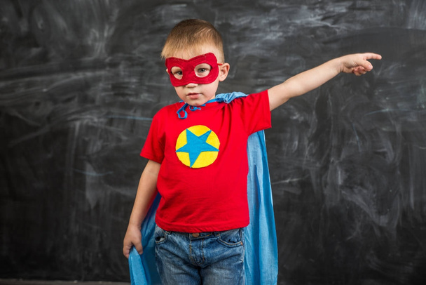 boy superhero in a blue Cape red mask and a red t-shirt with a star - Foto, afbeelding