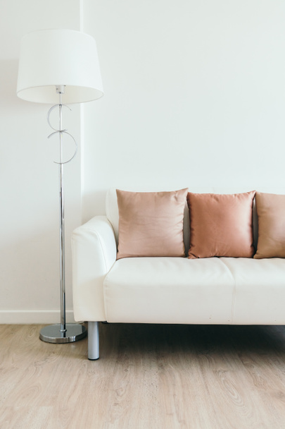Comodo cuscino su divano bianco con lampada leggera
 - Foto, immagini
