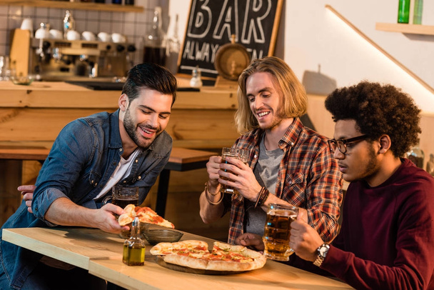 friends with pizza and beer in bar - Фото, изображение