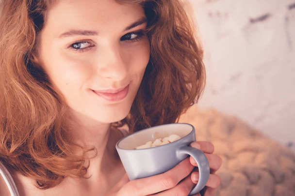 Beautiful woman drinking a coffee in her bed. Lifestyle concept. - Фото, изображение