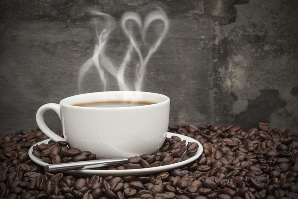 Гаряча кава з димом у формі серця, оточена кавовими зернами
 - Фото, зображення