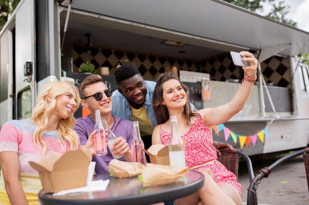 happy young friends taking selfie at food truck - Photo, image