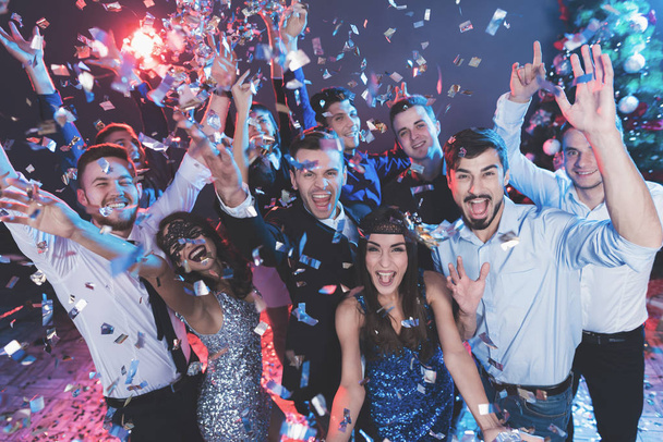 Young people have fun at a New Year's party. Around them flies confetti. They are having fun. - Foto, Bild