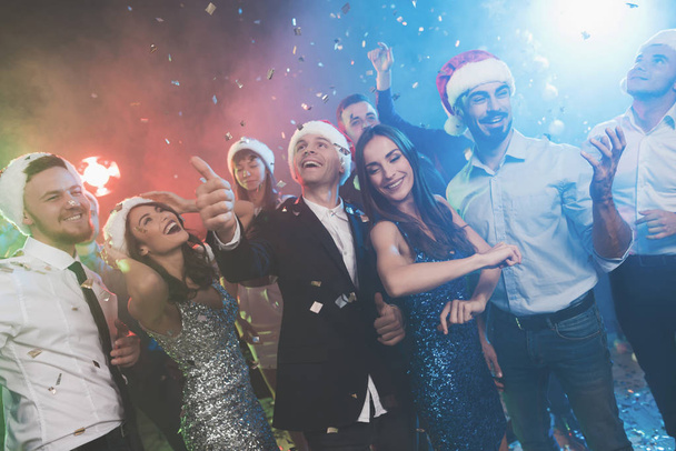 Young people have fun at a New Year's party. The guys put on Santa Claus hats. - 写真・画像