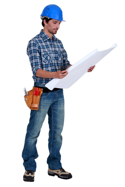 Tradesman examining a blueprint - Zdjęcie, obraz