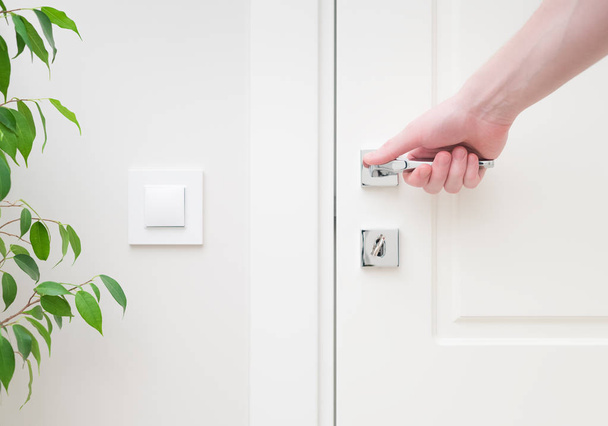 Male hand holding modern door handle. Close-up elements of the interior of the apartment - Φωτογραφία, εικόνα