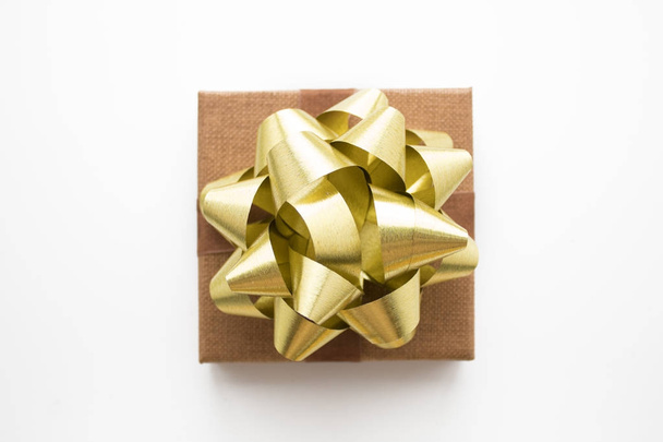 gift box with gold bow ribbon on white isolated in chistmas conc - Fotografie, Obrázek