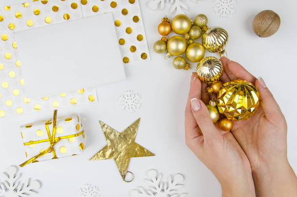 Woman hold golden christmas balls in hands and prepare for decorating Christmas tree.Flat lay, top view. Merry christmas greeting card. Happy hollidays mockup - Foto, Bild