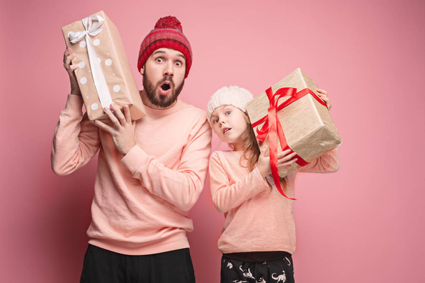 Portrait of a surprised little girl with her father holding a Christmas present - 写真・画像