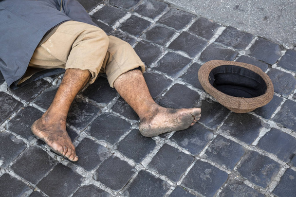 Un mendicante senzatetto giace per strada
 - Foto, immagini