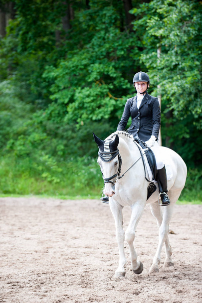 Adolescente chica ecuestre en vestido uniforme a caballo en son
 - Foto, imagen