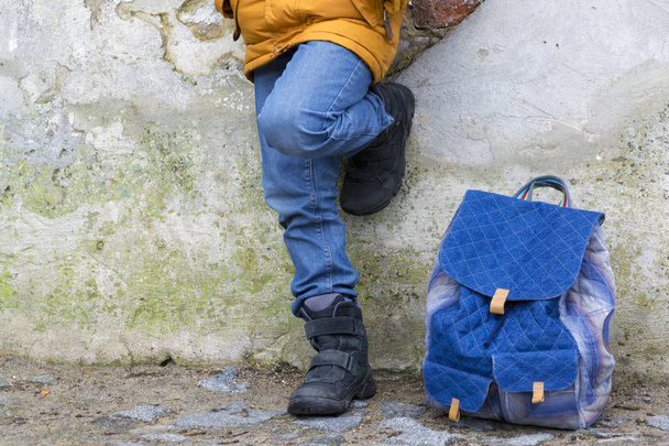 Kid boy pernas e mochila contra a parede
 - Foto, Imagem