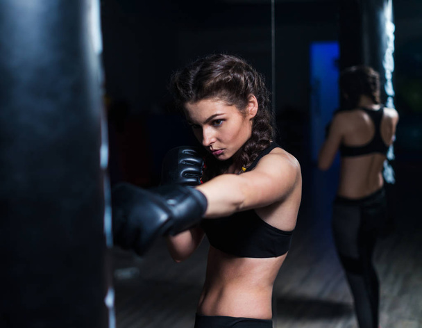 Young fighter boxer girl in training with heavy punching bag - Foto, Imagem