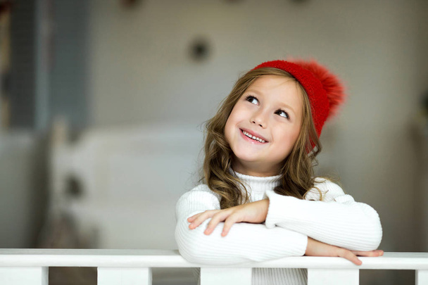 Portret uśmiechający się małą dziewczynką. Piękna dziewczyna mało obchodzi Boże Narodzenie. - Zdjęcie, obraz