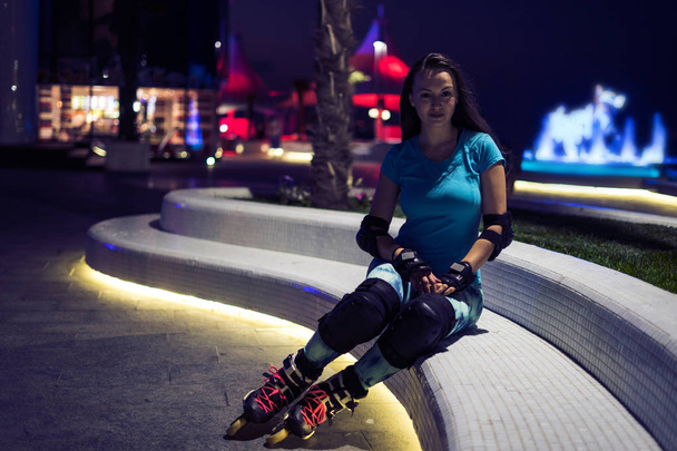 Kaukasische Mädchen genießt Rollschuhlaufen in der Nacht Stadt mit Lichtern in Bokeh - Foto, Bild