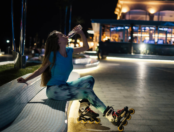 patinaje sobre ruedas chica es beber agua de botella de plástico
 - Foto, Imagen