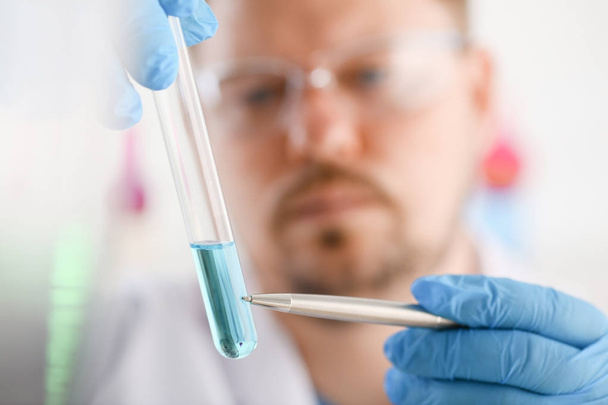 A male chemist holds test tube of glass - Fotoğraf, Görsel