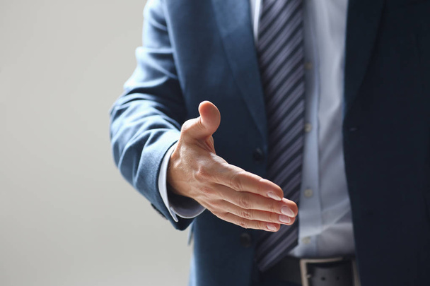 Człowiek w garniturze uścisnąć rękę jako cześć w biurze - Zdjęcie, obraz