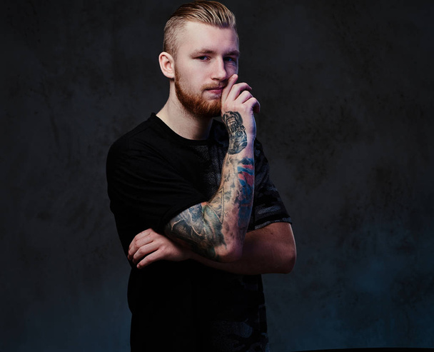 Молодой мужчина с татуировками на руке
 - Фото, изображение