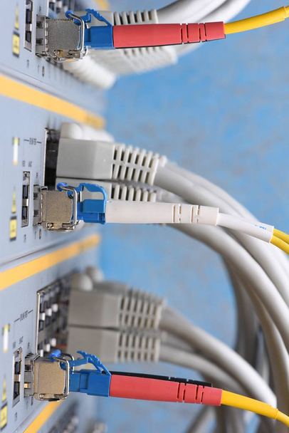 Fibra óptica y cables de red conectados al conmutador en el centro de datos, tecnología de red de Internet
 - Foto, imagen
