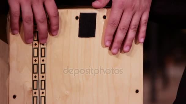 Dobos zenész játszik egy ütős eszköz Cajon. Közelről. Felvétel a zenei téma. - Felvétel, videó