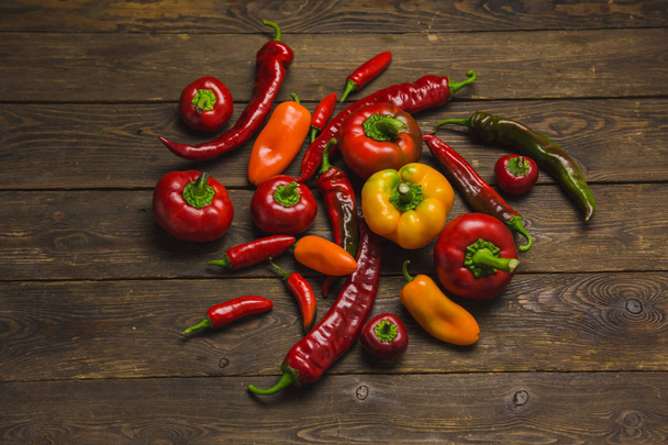 variety of peppers on a wooden background - Фото, изображение