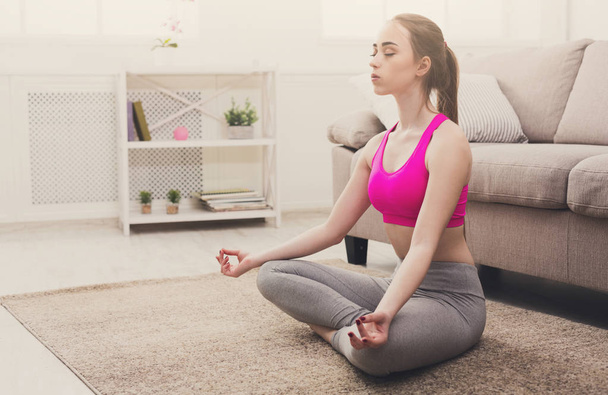 Woman training yoga in lotus pose, closeup - 写真・画像