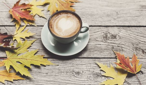Autumn cappuccino coffee cup on rustic wood background - Фото, зображення