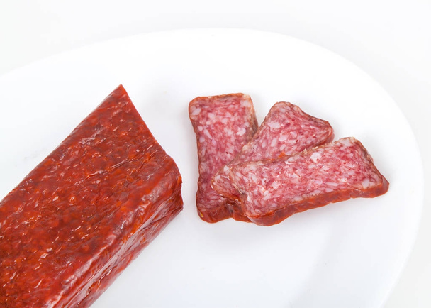 Slices italian salami sausage on white background - Фото, изображение