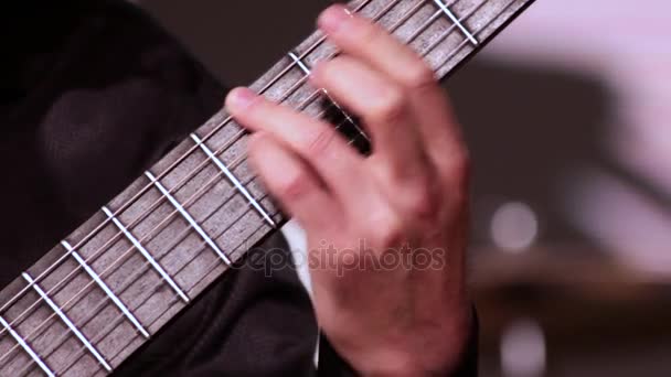 Мужчина играет на гитаре. Видеозапись на музыкальную тему. Крупный план левой руки, который ставит аккорды на лад
. - Кадры, видео