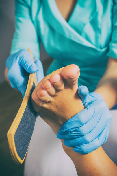 Pedicura removedor de piel muerta raspa de pie mujer en salón de uñas
 - Foto, Imagen