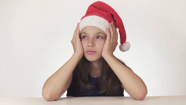 Beautiful unhappy teenage girl sad about the gift that did not get on white background - Foto, imagen
