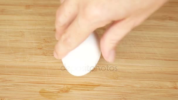 a person turns a chicken egg to see if it is cooked or raw. the raw egg turns slowly. 4k. space for copying - Πλάνα, βίντεο