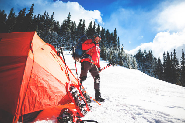 Bergsteiger in der Nähe des Zeltes mit Schneeschuhen. - Foto, Bild