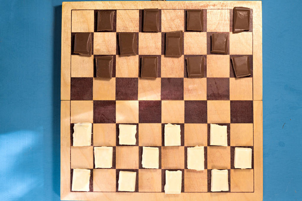 Twee bars van chocolade op een schaakbord - Foto, afbeelding