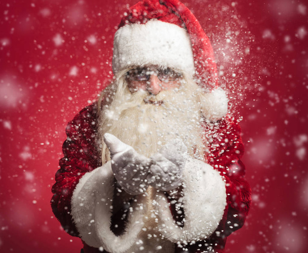 Santa claus navátý sníh vločky jeho rukou - Fotografie, Obrázek