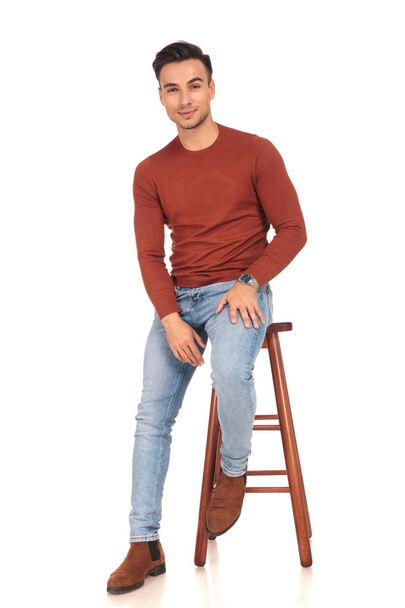 seated young casual man with hand on thigh - Photo, Image